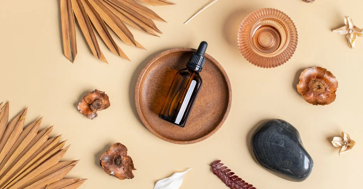 Vue de dessus d'une bouteille d'huile essentielle avec des éléments naturels sur un fond beige, promouvant le bien-être et la relaxation.